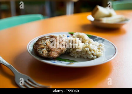Essen für Kinder im Vorschulalter. Graupen eines Steak Schnitzel auf einer weißen Platte Stockfoto