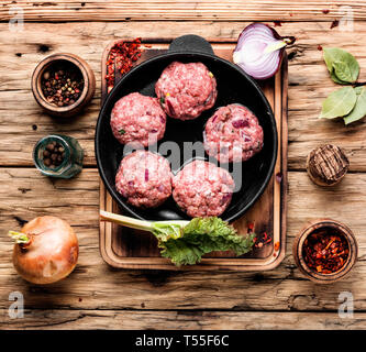 Fleisch Kugeln von rohem Rindfleisch Kraft - Fleisch in Gusseisen Pfanne. Frikadellen - Vorbereitung zum Kochen Stockfoto