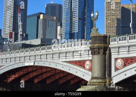 Detail von eine der vielen Brücken über den Fluss Yarra in Melbourne mit Säulen und Bögen und Wolkenkratzer im Hintergrund. Stockfoto