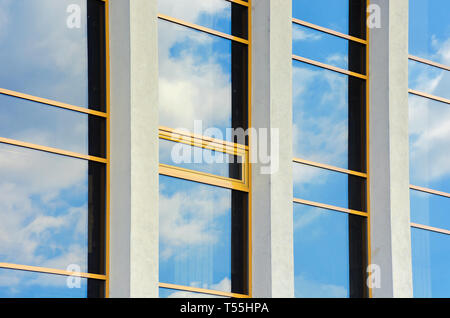 Schöne urbane Architektur Hintergrund. Fenster Reflexion der Wolken an einem blauen Himmel. Perspektive Seitenansicht mit drei Spalten Stockfoto