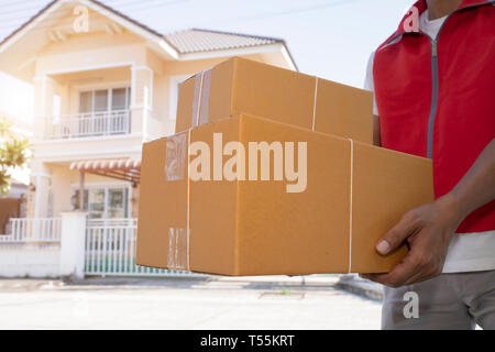 Lieferung Mann in der roten Uniform Paket übergabe Boxen an Empfänger-Kurierdienst Konzept - Bild Stockfoto