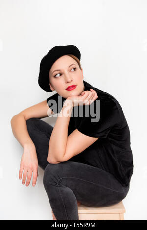 Junge Frau mit Baskenmütze und roten Lippenstift Stockfoto