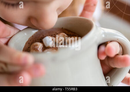 Mädchen trinken heiße Schokolade mit Marshmallows Stockfoto