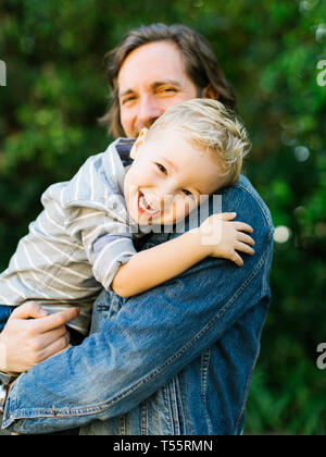 Lächelnd Vater seinen Sohn Holding Stockfoto
