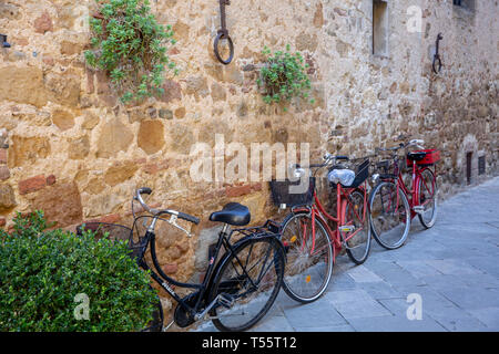 Reihe von Fahrrädern lehnt an Steinmauer in der Toskana Dorf Pienza am Herbsttag, Toskana, Italien Stockfoto