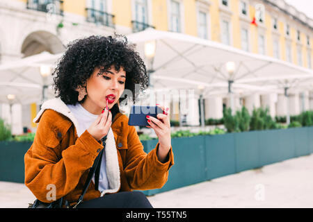 Junge Frau mit roten Lippenstift mit smart phone Stockfoto