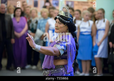 Belarus, die Stadt Gomel September 15, 2016, die zentrale Bibliothek. Nacht der Museen. Die alte Frau tanzt indischen Tänzen. Aktives Altern Stockfoto