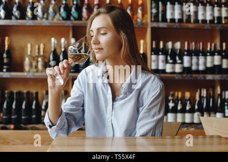 Junge Frau sniffing Glas Weißwein Stockfoto