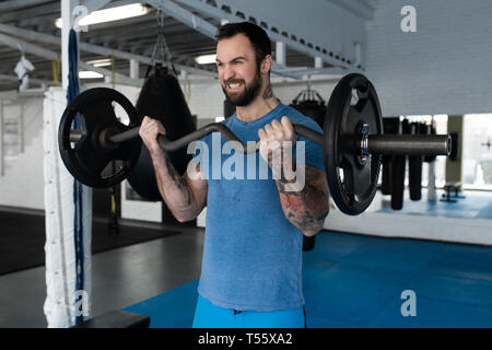 Mitte der erwachsene Mann Gewichtheben in der Turnhalle Stockfoto