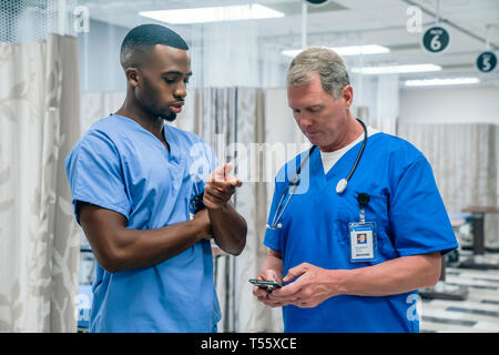 Arzt und Krankenschwester, die Smart Phone im Krankenhaus Stockfoto