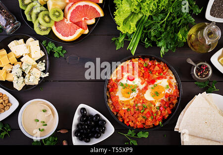 Türkisches Frühstück - Shakshuka, Oliven, Käse und Obst. Reichhaltigen Brunch. Ansicht von oben Stockfoto