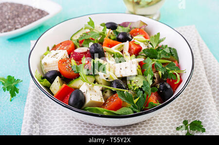 Griechischer Salat mit Gurken, Tomaten, Paprika, Salat, grüne Zwiebeln, Schafskäse und Oliven mit Olivenöl. Gesundes Essen. Stockfoto