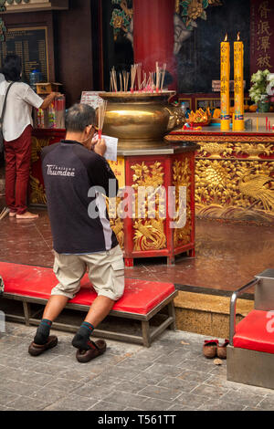 Thailand, Bangkok, Chinatown, Thanon Yaowarat, Kuan Yim Schrein, Mann, der betet mit Räucherstäbchen Stockfoto