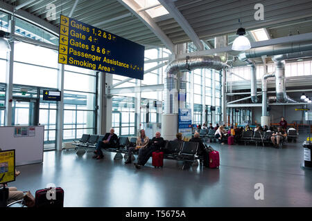 Passagiere warten in Bournemouth Flughafen Abflughalle Innenraum mit Zeichen zu den Toren Stockfoto