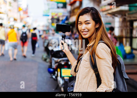 Junge asiatische Frau touristische Frau mit einem Gimbal mit Smartphone und Aufzeichnung von Videos für den Blog. Travel Blogger und vlogger Konzept Stockfoto