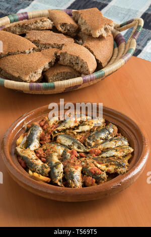 Traditionelle marokkanische Tajine mit Sardinen, Gemüse und Brot für das Abendessen Stockfoto