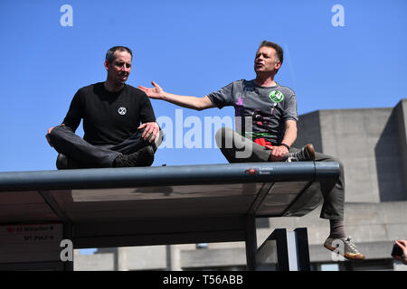 (Von links nach rechts) Olympiasieger Etienne Stott und Chris Packham eine Rede auf einer Bushaltestelle während das Aussterben Rebellion Demonstration auf der Waterloo Bridge in London machen. Stockfoto