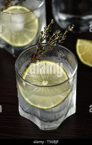 Gin Tonic mit einer Scheibe Limette und Zweige Thymian Stockfoto