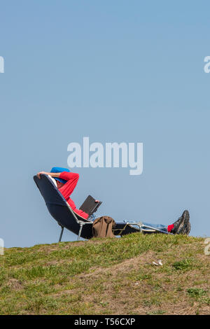Mann ein Sonnenbad am Bett oder liege am Meer an einem heißen und sonnigen Sommer Tag auf der Insel Wight. Stockfoto