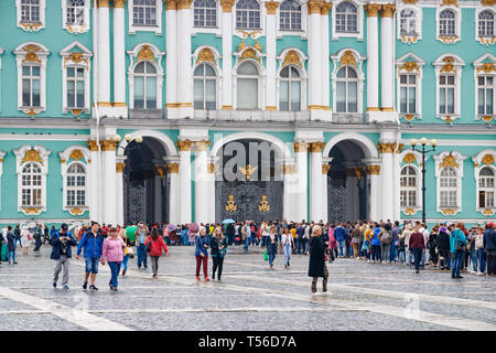 Nicht identifizierte Touristen im Einklang am Eingang der Eremitage am Schlossplatz an einem regnerischen Tag warten. Sankt Petersburg, Russland. Stockfoto