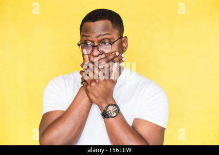 Überrascht schöne afrikanische amerikanische Mann in Gläser deckt Mund im Schlag. Stockfoto