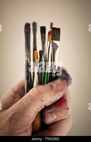 Malen Sie Bürsten verschiedener Größen in einem mans Hand Stockfoto