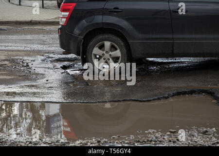 Autoreifen über durch große Schlagloch von Wasser Stockfoto