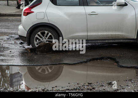 Autoreifen über durch große Schlagloch von Wasser Stockfoto