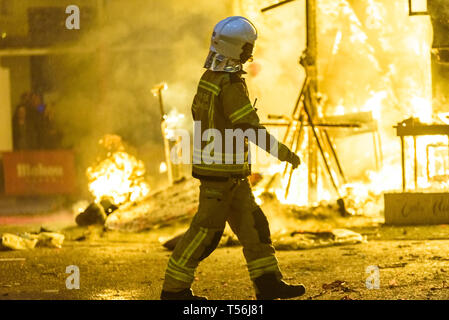 Feuerwehrleute rund um ein Feuer, verursacht durch eine Falla Valenciana Controlling die Flammen des Feuers. Stockfoto