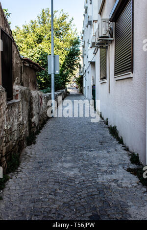 Eine schmale städtische Straße mit Steinböden und alten Vintage Gebäude. Foto bei bazl/Izmir getroffen hat. Stockfoto
