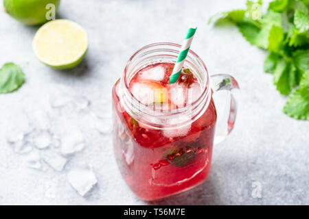 Rote Beere Cocktail oder Eis Tee in Dose mit Trinkschlauch auf konkreten Hintergrund. Horizontale Stockfoto