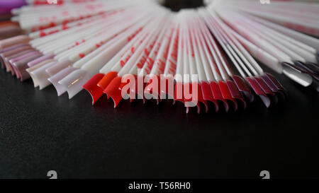 Nail Art Design. Der Falsche Nägel für Maniküre. Lack Farbpalette für Nagel Malerei. Künstliche Nägel auf transparenter Basis. Auf rote Farbe konzentriert Stockfoto