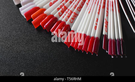 Nail Art Design. Der Falsche Nägel für Maniküre. Lack Farbpalette für Nagel Malerei. Künstliche Nägel auf transparenter Basis. Auf rote Farbe konzentriert Stockfoto