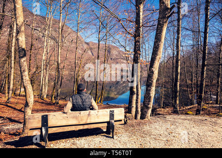 Ein Mann auf der Bank sitzen und auf die See Stockfoto