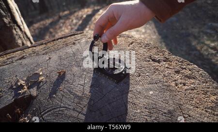 Thema navigation Grundstück und Route. Reisende auf der Suche nach Richtung mit einem Kompass im Wald. Blick auf Händen close-up Stockfoto
