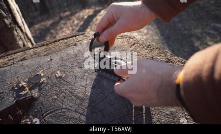 Thema navigation Grundstück und Route. Reisende auf der Suche nach Richtung mit einem Kompass im Wald. Blick auf Händen close-up Stockfoto