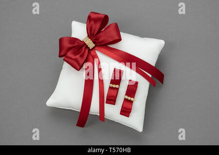 Hochzeit Kissen für Ringe mit roten Bändern verziert. Stockfoto