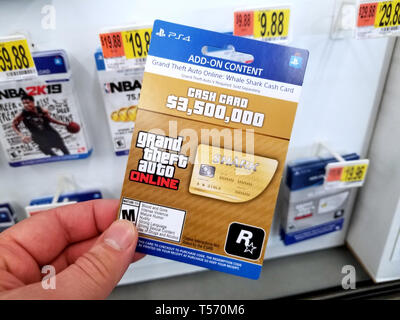 PLATTSBURGH, USA - Januar 21, 2019: CASH-Karte von Grand Theft Auto video game in eine Hand von einem Käufer bei Walmart Stores. Stockfoto