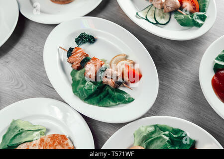 Lachs Kebab auf Holzspieße mit frischem Gemüse. Gerichte für ein Picknick Stockfoto