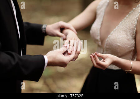 Erschossen Sie Moment, wenn der Bräutigam den Ring einerseits eine junge Braut bringt. Stockfoto
