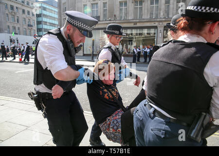 Ein Umweltaktivist ist gesehen zu werden, die von den Polizisten am Oxford Circus während des fünften Tages der Klimawandel Protest vom Aussterben Aufstandsbewegung Gruppe verhaftet. Eine große Anzahl von Polizeipräsenz rund um die rosa Yacht wie Sie un-Bond die Aktivisten, die sich selbst und die Polizei geklebt bereitet Sie von der Website zu entfernen. Nach Angaben der Polizei traf, über 1000 Aktivisten wurden verhaftet, da die Demonstration begann am 11. April 2019. Stockfoto