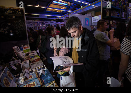 Athen, Griechenland. 21 Apr, 2019. Ein Mann gesehen Lesung durch ein Buch während des Comicdom-Con Festival, einem dreitägigen Comics Festival, Platz an der Hellenic American Union nahm. Credit: SOPA Images Limited/Alamy leben Nachrichten Stockfoto