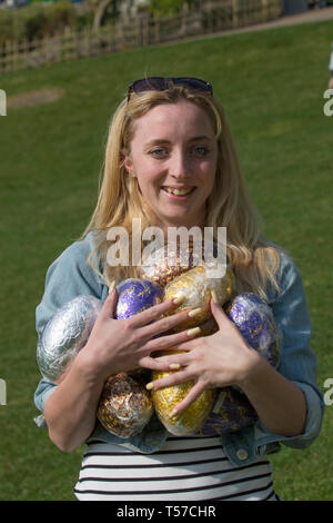 Preston, Lancashire. April 2019. Wetter in Großbritannien. Sonniger Start zum traditionellen Ostereierwalzen im Avenham Park an nur zwei Orten in England, wo das traditionelle Osterfest praktiziert wird. Charlotte, die mit der Familie den Park besucht, sammelt die erste Reihe von Schokoladeneiern, die in der öffentlichen Parklandschaft am Hang hinuntergerollt sind. Kredit; Stockfoto