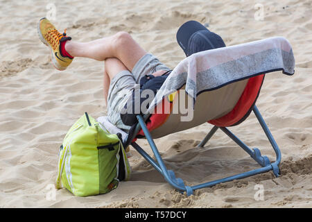 Bournemouth, Dorset, Großbritannien. 22 Apr, 2019. UK Wetter: Nach einem dunstigen Start das herrliche Wetter mit warmen und sonnigen Wetter fort, als beachgoers Kopf zum Meer die Wärme und Sonnenschein in Bournemouth Strände am Ostermontag zu genießen, bevor das Wetter ändert sich und die Rückkehr zur Arbeit. Man Relaxen im Stuhl am Strand. Credit: Carolyn Jenkins/Alamy leben Nachrichten Stockfoto