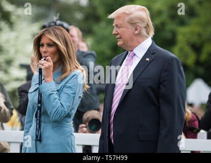 Washington, District of Columbia, USA. 22 Apr, 2019. First Lady Melania Trump verbunden von United States President Donald J. Trumpf bläst eine Pfeife eine Wärme, die sich im Weißen Haus Easter Egg Roll im Weißen Haus in Washington, DC am 22. April 2019 zu beginnen. Credit: Kevin Dietsch/Pool über CNP Credit: Kevin Dietsch/CNP/ZUMA Draht/Alamy leben Nachrichten Stockfoto