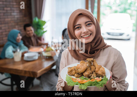 Muslimische Frau mit Essen für Familie serviert Stockfoto