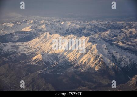 Luftbild vom Flugzeug der Wasatch Front Rocky Mountain Range mit schneebedeckten Gipfeln im Winter einschließlich städtischer Städten Provo, Farmington Bount Stockfoto