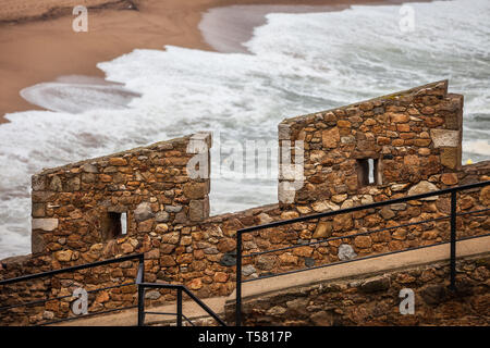 Defensive mittelalterlichen Steinmauer Zinne mit zwei Zinnen und Schießscharten in der alten Stadtmauer Festung in Tossa de Mar, Katalonien, Spanien Stockfoto