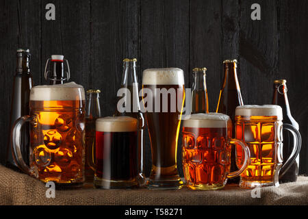Sortiment von Biergläsern auf Tabelle mit Leinwand Tuch, dunklen Hintergrund Stockfoto