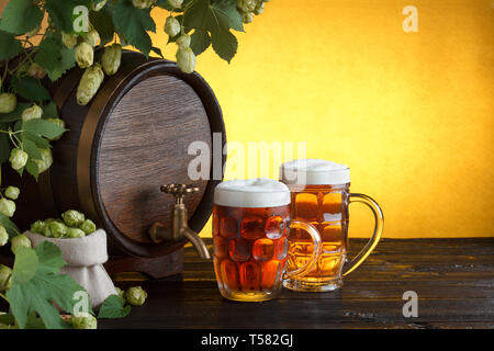Vintage Barrel Bier mit zwei Bier Gläser und Rahmen von frischem Hopfen auf hölzernen Tisch noch leben, kopieren Raum Stockfoto